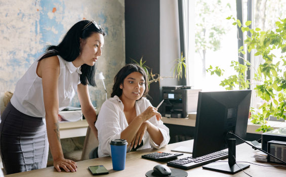 Two women in an office looking at a computer screen