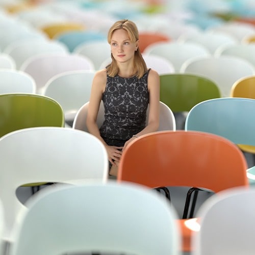 Woman sitting alone among conference room chairs