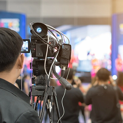 Image of the back of a videographer, recording an event
