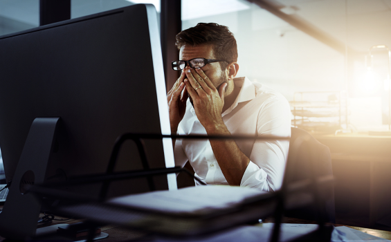 man sitting at a computer looking frustrated